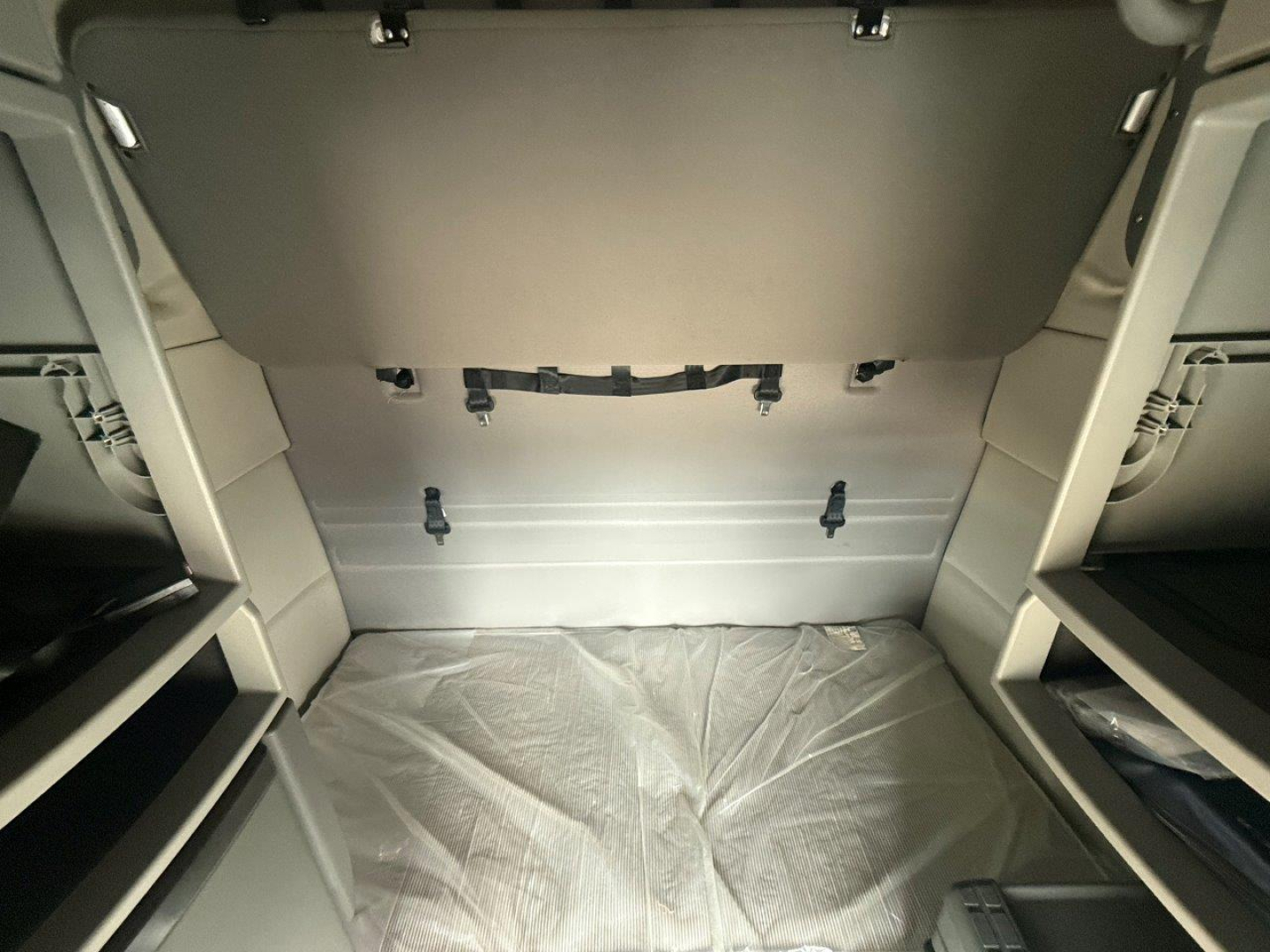  Volvo VNR cab interior showing sleeper bunk area with side shelves and storage panels.