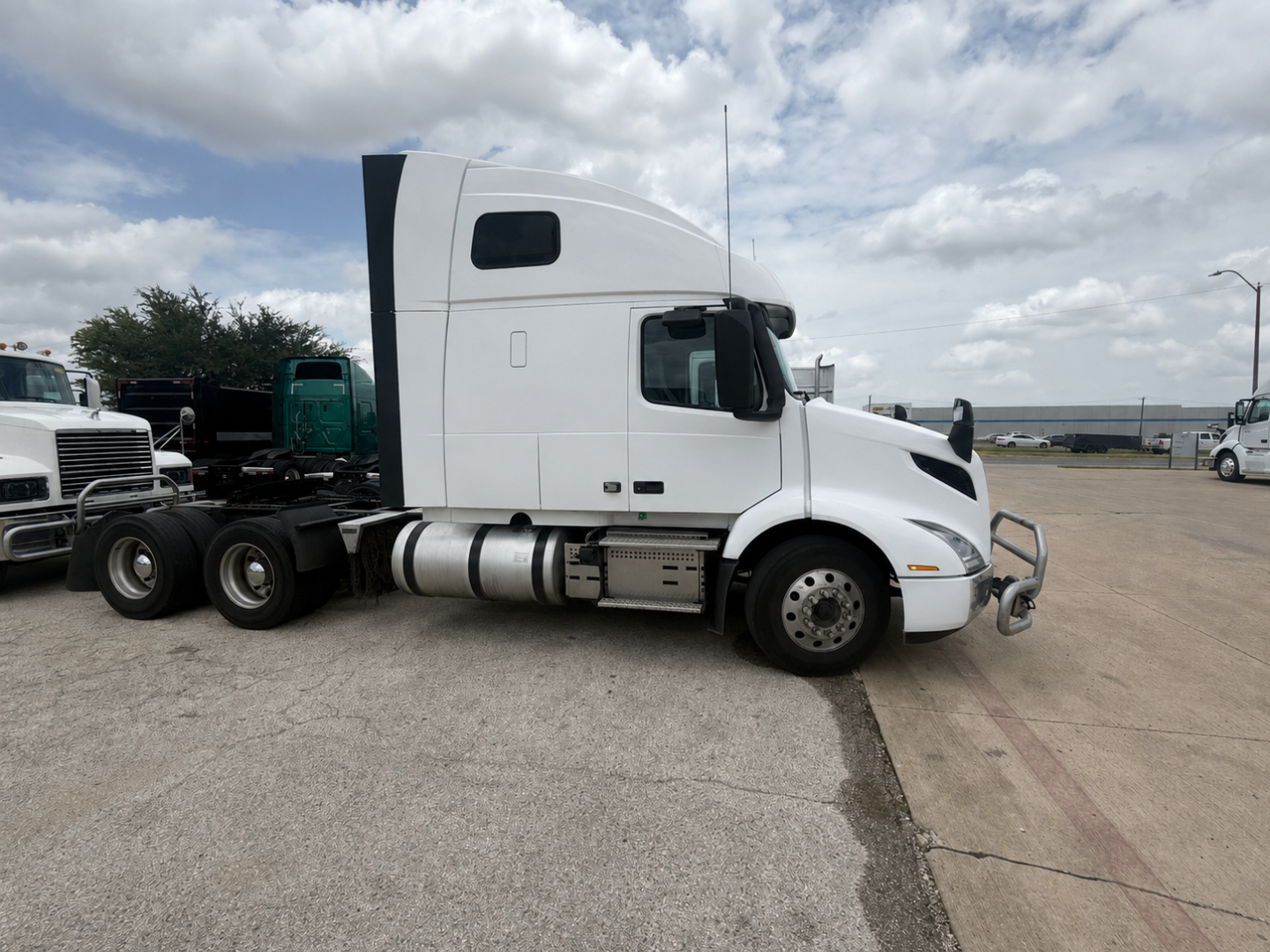  Volvo VNR64T660 sleeper tractor tractor side view revealing cab, fuel tanks, and front bumper with chrome grille.