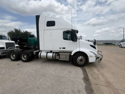  Volvo VNR64T660 sleeper tractor tractor side view revealing cab, fuel tanks, and front bumper with chrome grille.