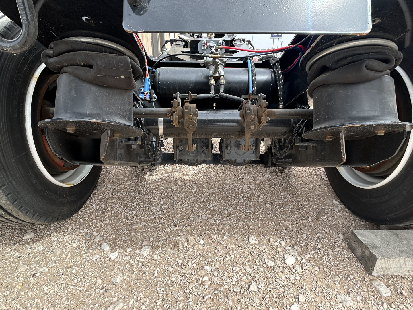 Front view of a Load King trailer undercarriage showing flip axle, air springs, dual tires, and suspension components.