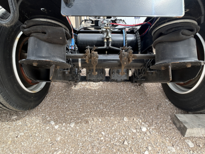 Front view of a Load King trailer undercarriage showing flip axle, air springs, dual tires, and suspension components.