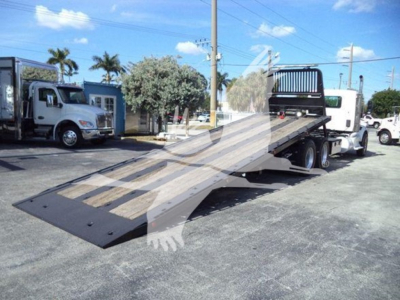 2016 Peterbilt 567 rollback tow truck with ramp bed deployed, metal loading ramp and white cab visible, VIN 1NPCL70XXGD301476 details on listing.
