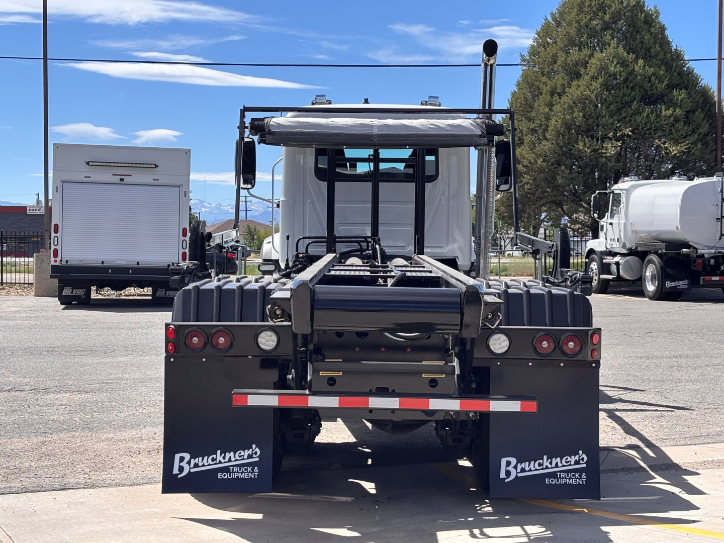 Back view of 2027 Mack GR64B roll-off truck showing rear chassis, mud flaps with Bruckner's Equipment logo, and tail lights.