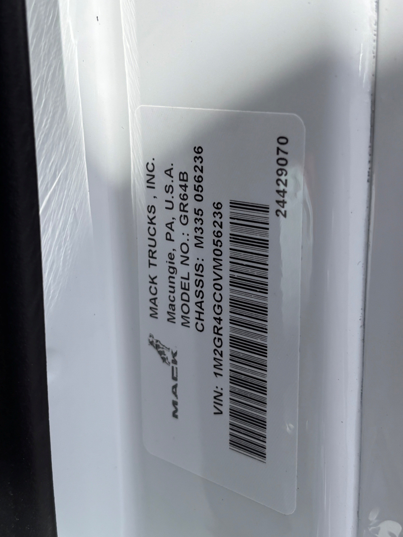 Mack Trucks label on a white surface showing VIN and other details: MACK TRUCKS INC., MACK TRUCKS I.N.C., MACK TRUCKS, INC. MANUFACTURING A, MACK BUSINESS, MCD… VIN: 1M2GR4GC0VM056236, 24 4 29070, other barcode text.