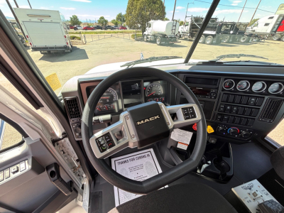 Cab interior of a 2027 Mack GR64B showing steering wheel with MACK logo, dashboard gauges, and center control panel.