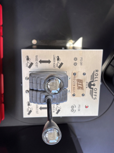 Roll-off controls panel with levers and labels: Rolloff Off/On, Raise/Lower, Tilt, and three labeled indicators; knob appears with wear-resistant cover.