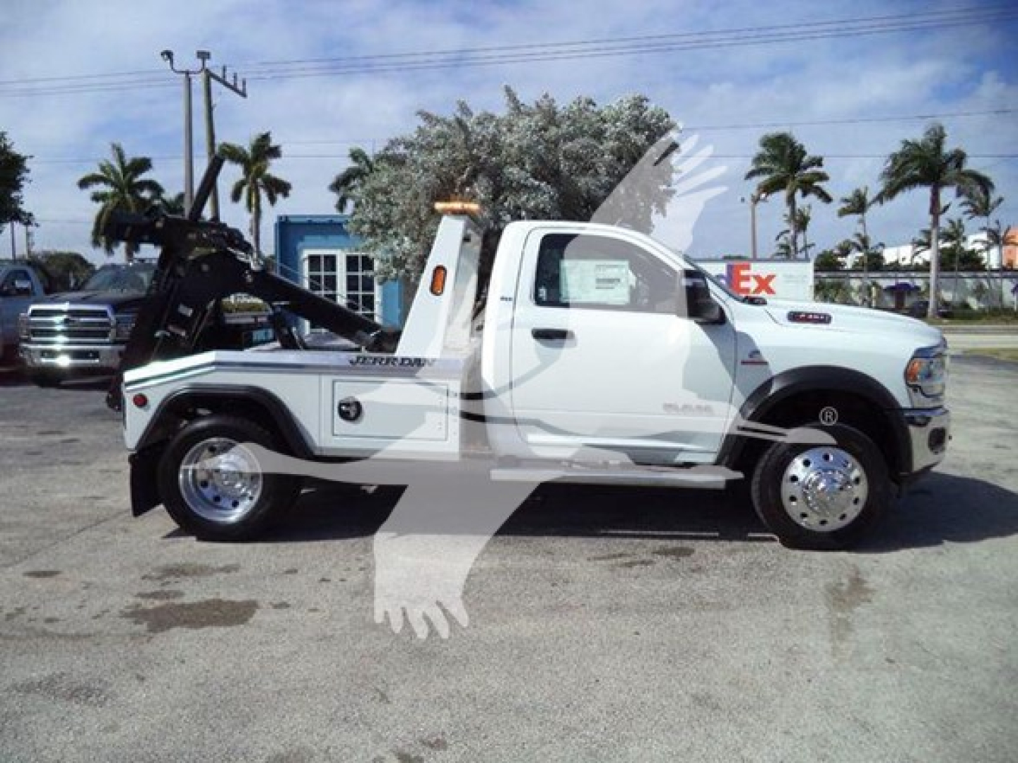 Ram 4500 Tow Truck in service body configuration with wheel-lift, white cab and chassis, prominent winch mount at rear, side steps, on-road background