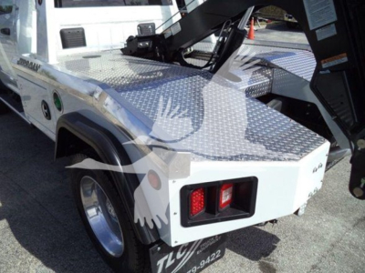 Ram 4500 Winch truck bed showing diamond plate deck and rear taillights, white body with text decals, winch equipment and hitch area visible.