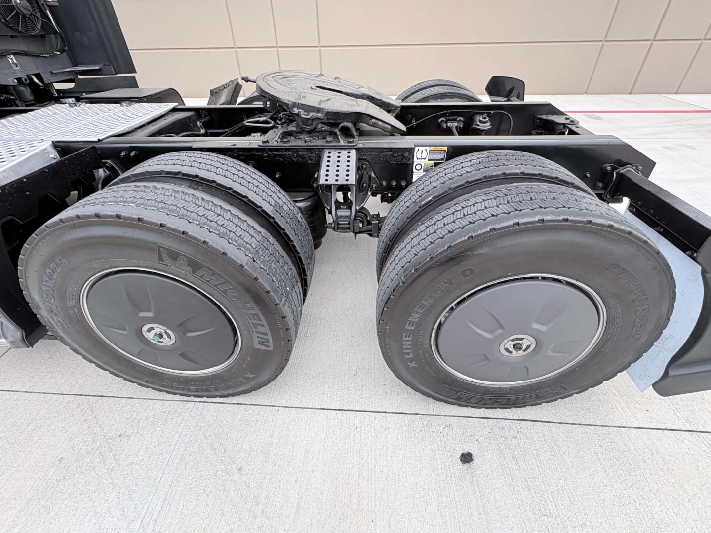 Dual rear wheel assembly of a 2022 Kenworth T680 tractor showing twin drive tires and suspension components.