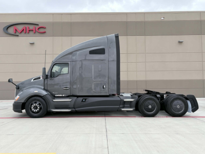 Kenworth T680 tractor-trailer side view showing gray cab and twin rear axles.