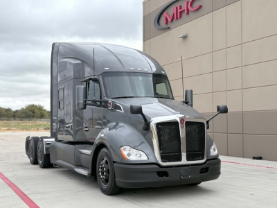 Kenworth T680 truck in a parking area showing aerodynamic cab with dual mirrors and front chrome grille