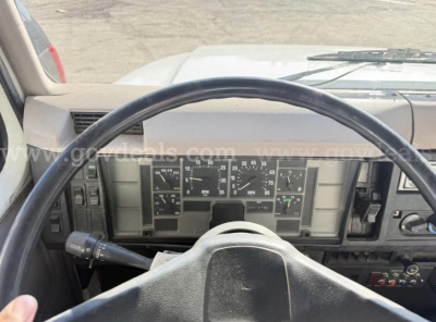 Truck dashboard and steering wheel view from 1996 International 4700 showing instrument cluster and steering wheel in-service cab interior.