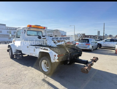 Tow truck rear quarter view showing towing arm and winch with amber beacon light on cab roof, International 4700, VIN 1HTSCABM7TH248809, stock 30619-1.