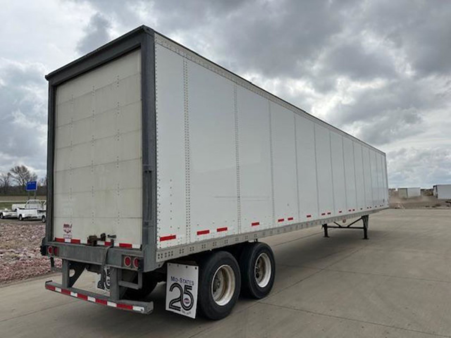 Trailer side and rear of a 2016 Wabash van trailer showing dual rear axles and white exterior.