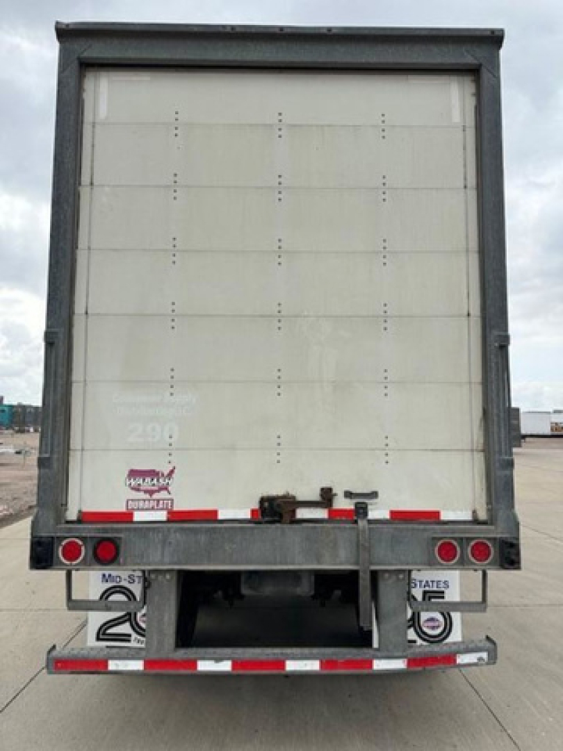Rear view of a 2016 Wabash van trailer showing a closed rear door with bumper and taillights, license plate area, and reflective red/white markings.