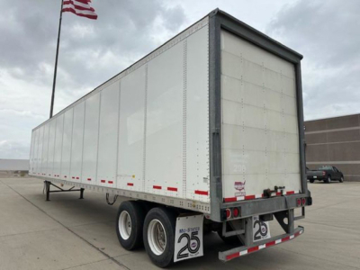 Trailer side and rear view showing a white 2016 Wabash van trailer with dual rear axles and reflective red/white strips.