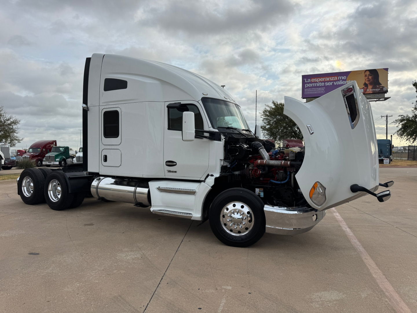 Kenworth T680 conventional sleeper truck with hood open showing engine area and side view mirrors.