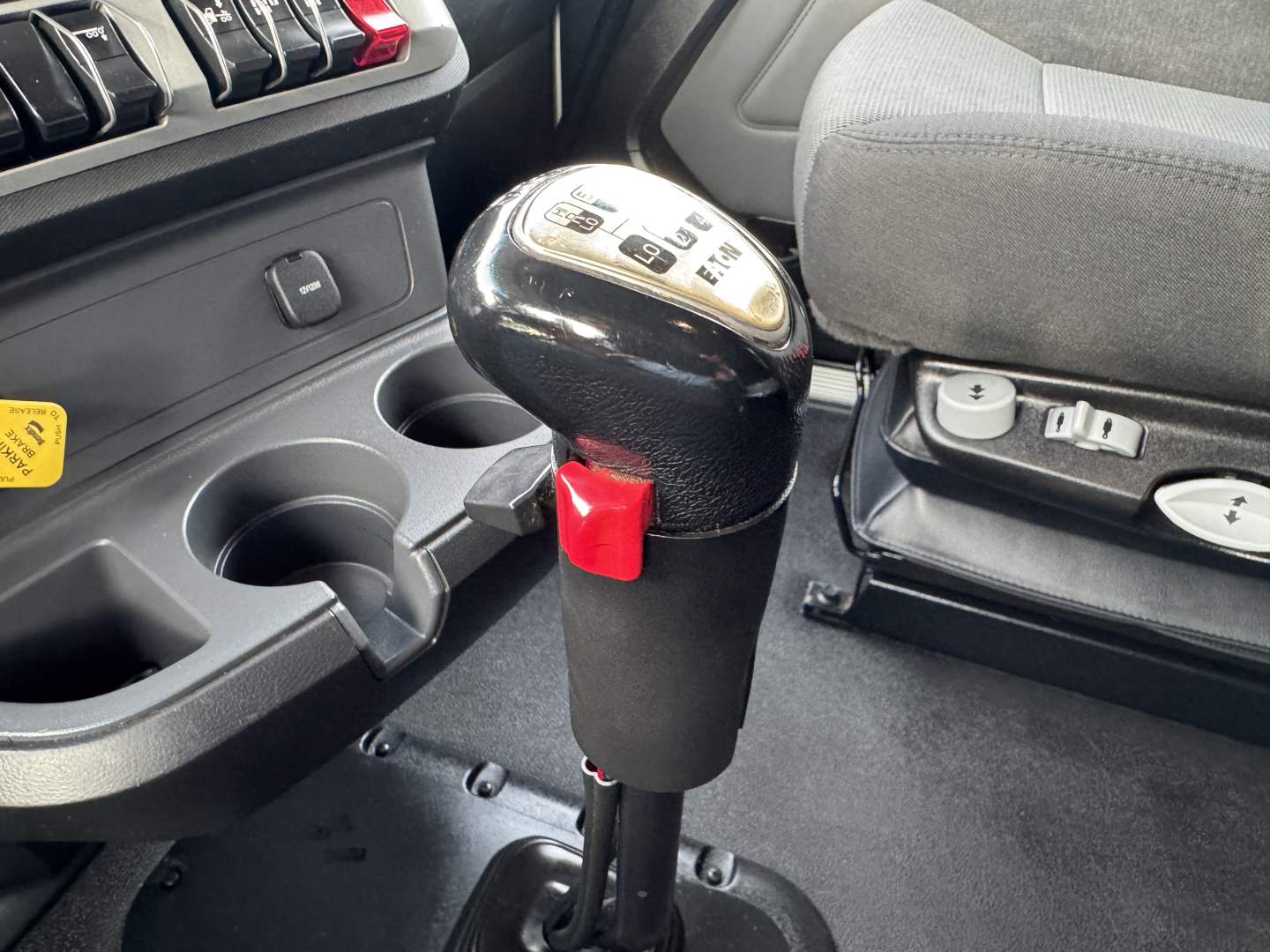 Kenworth T680 interior showing gear shifter with 10-speed pattern and cup holders.