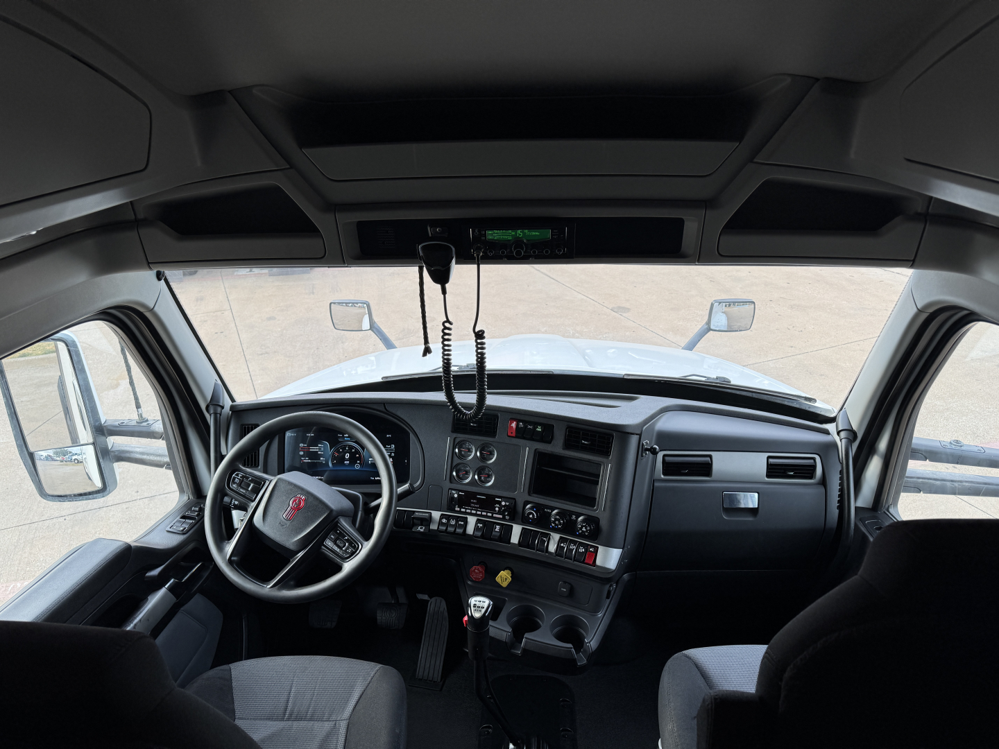 Kenworth truck interior dashboard and steering wheel cockpit view.