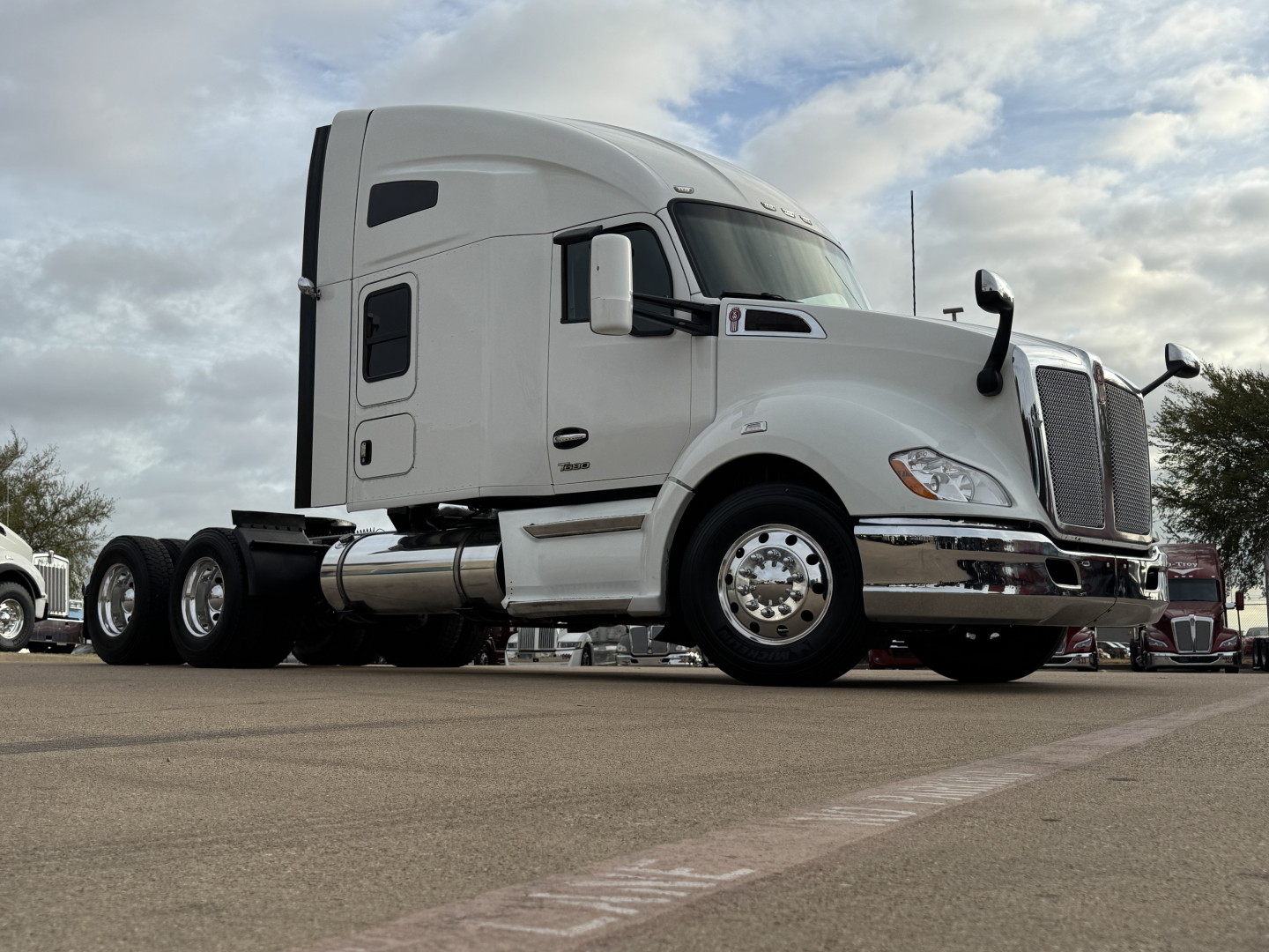 Kenworth T680 tractor-trailer cab in white side view showing sleeper and fuel tanks.