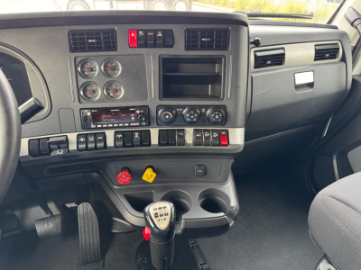 Kenworth T680 cab interior showing dashboard gauges and manual gear shifter.