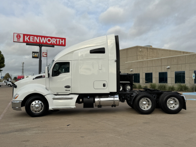 Kenworth T680 sleeper tractor in white, side view showing cab, fuel tanks, and dual rear axles.