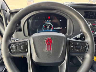 Kenworth T680 steering wheel and dashboard view showing instrument cluster and control buttons.