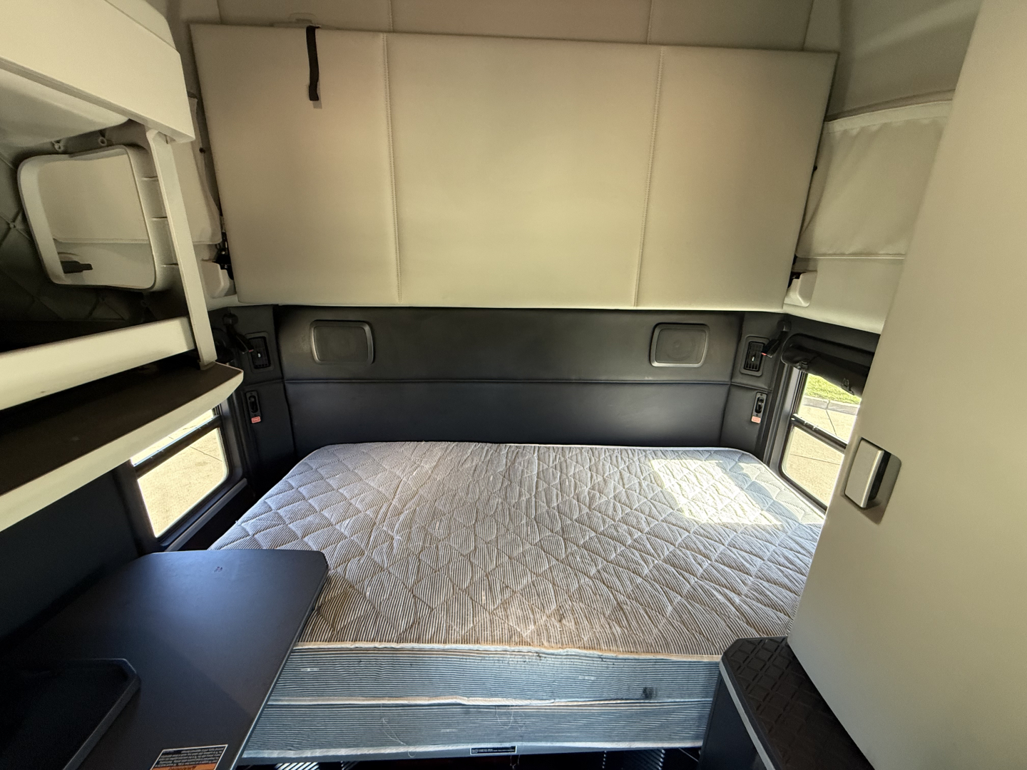 Kenworth T680 sleeper cab interior with bed and storage compartments visible
