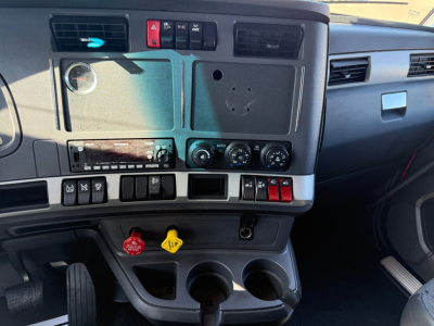 Kenworth T680 dashboard view showing control panel, ignition area, climate controls, and cup holders.
