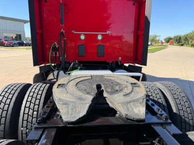 Truck fifth wheel area showing coupling area and rear of cab with red sleeper and lines.