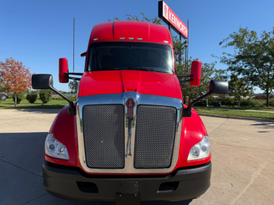 Kenworth T680 front view showing large dual grille with chrome surround and red cab; black bumper and prominent side mirrors.