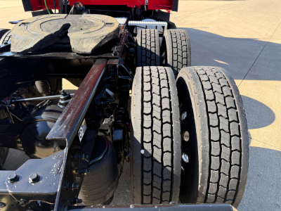 Kenworth T680 tractor rear with dual rear axles and fifth wheel; visible tires and chassis components
