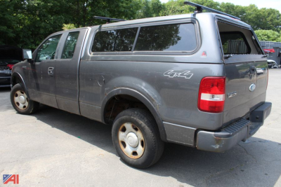 Ford F-150 pickup with 4x4 cap and cap canopy showing side view; gray paint and cargo canopy, 2007 model year.