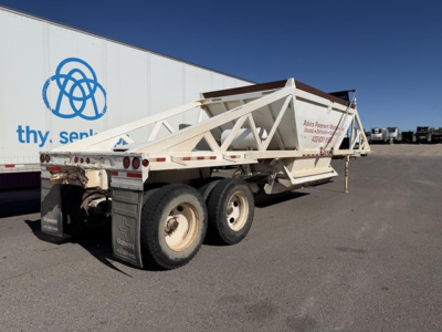 Trailer showing a white Ranco single point spring bottom dump trailer with dual rear axles and a long triangular frame. Visible text on side: 'Hain (illegible) Power...something' and rear plate area. Background includes a large white truck 