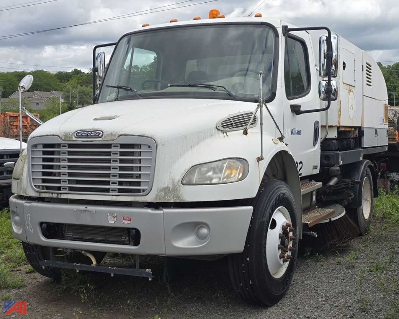 Freightliner M2 106 road sweeper truck side view with front grille, dual headlights, and sweeping equipment on rear body.