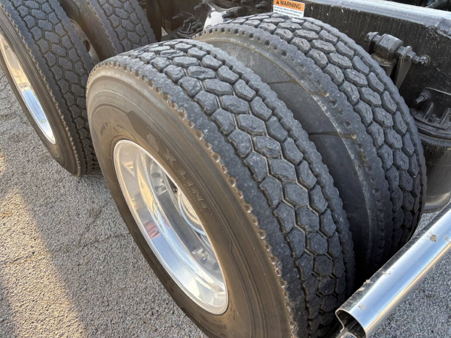 Freightliner Cascadia 126 truck axle and dual tires close-up showing tread pattern and wheel rims.