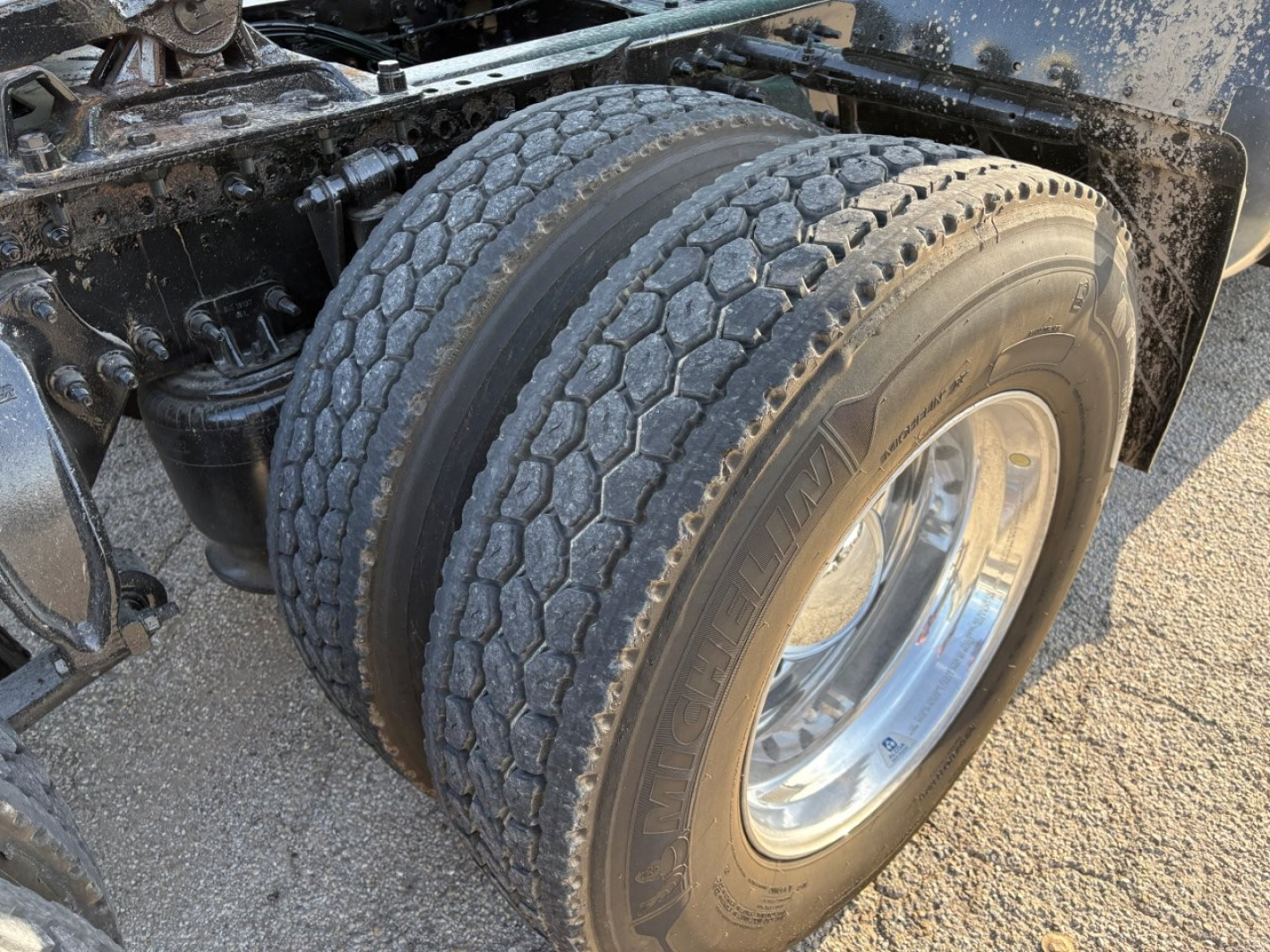 Truck axle and dual rear tires showing tread and chrome wheel on Freightliner Cascadia 126 chassis.