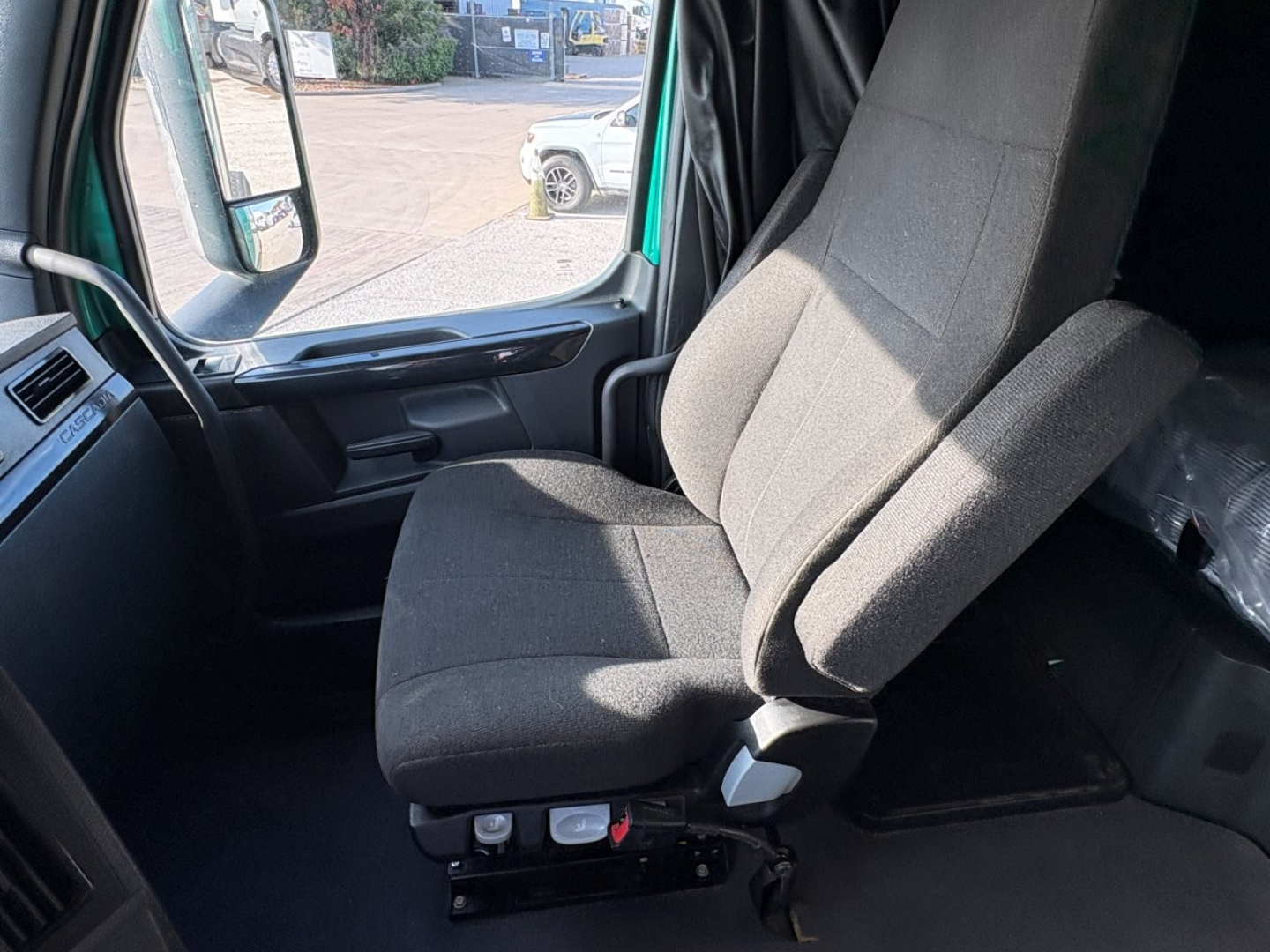 Tractor-trailer cab interior showing driver and passenger seats in a Freightliner Cascadia 126 truck.