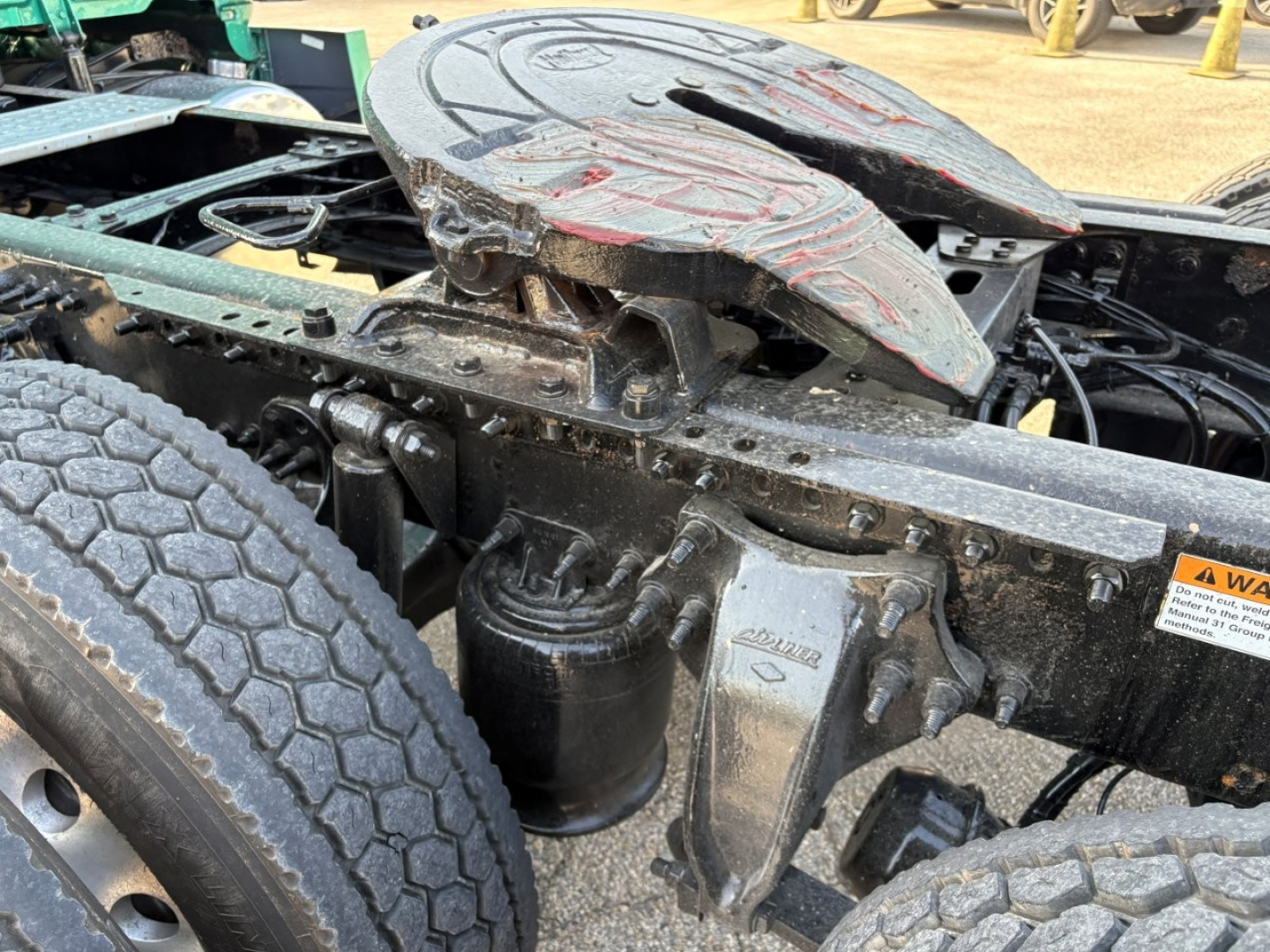 Freightliner Cascadia 126 truck chassis showing fifth wheel and suspension components with labels and hoses.