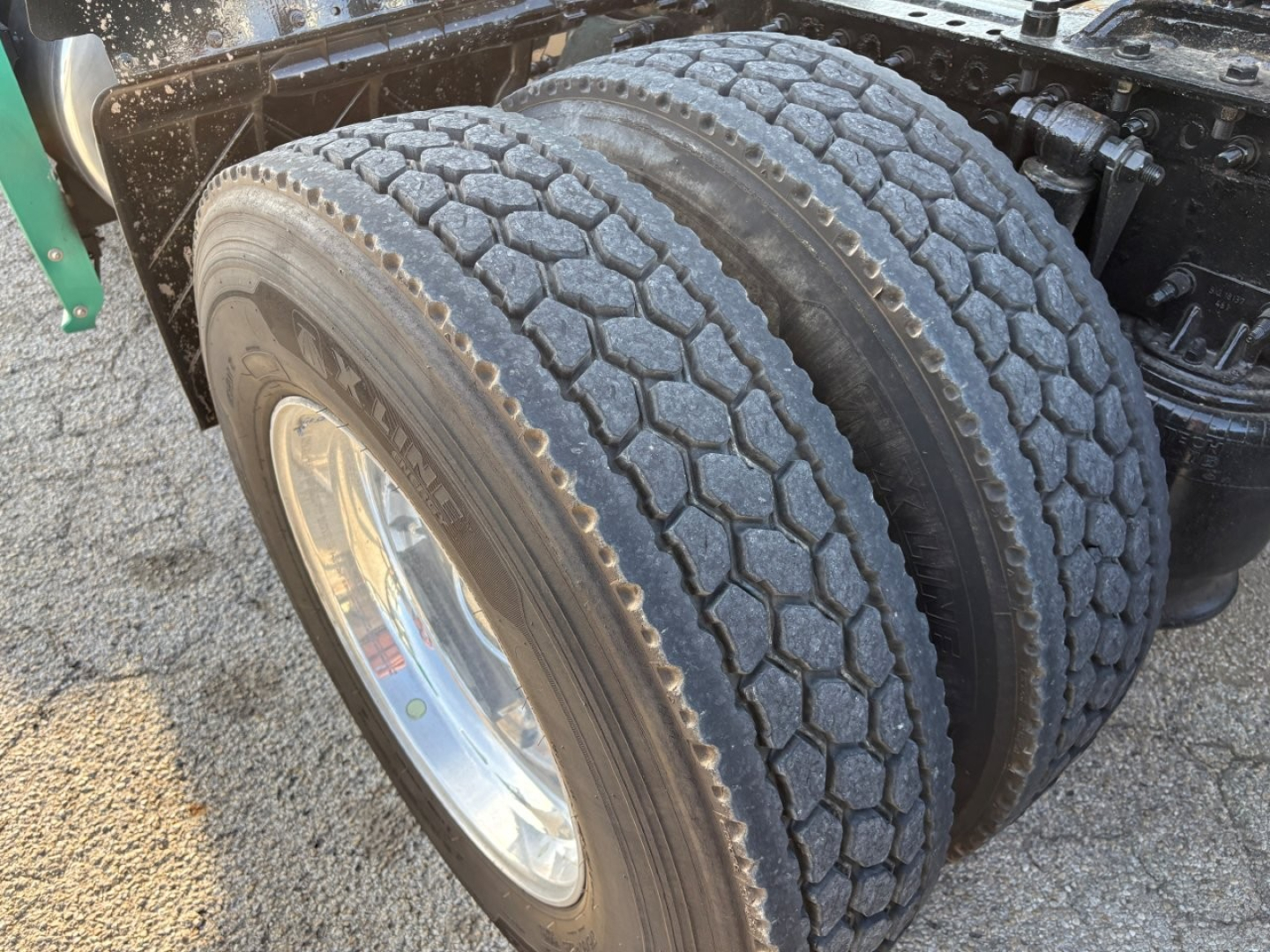 Dual rear tractor tires on a Freightliner Cascadia 126 truck showing tread pattern and wheel rims.