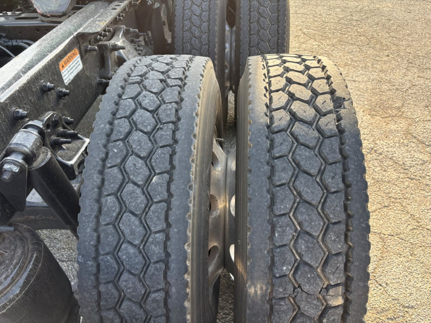 Truck rear dual tires and chassis framing of a 2023 Freightliner Cascadia 126 showing dual tires and wheel hubs.