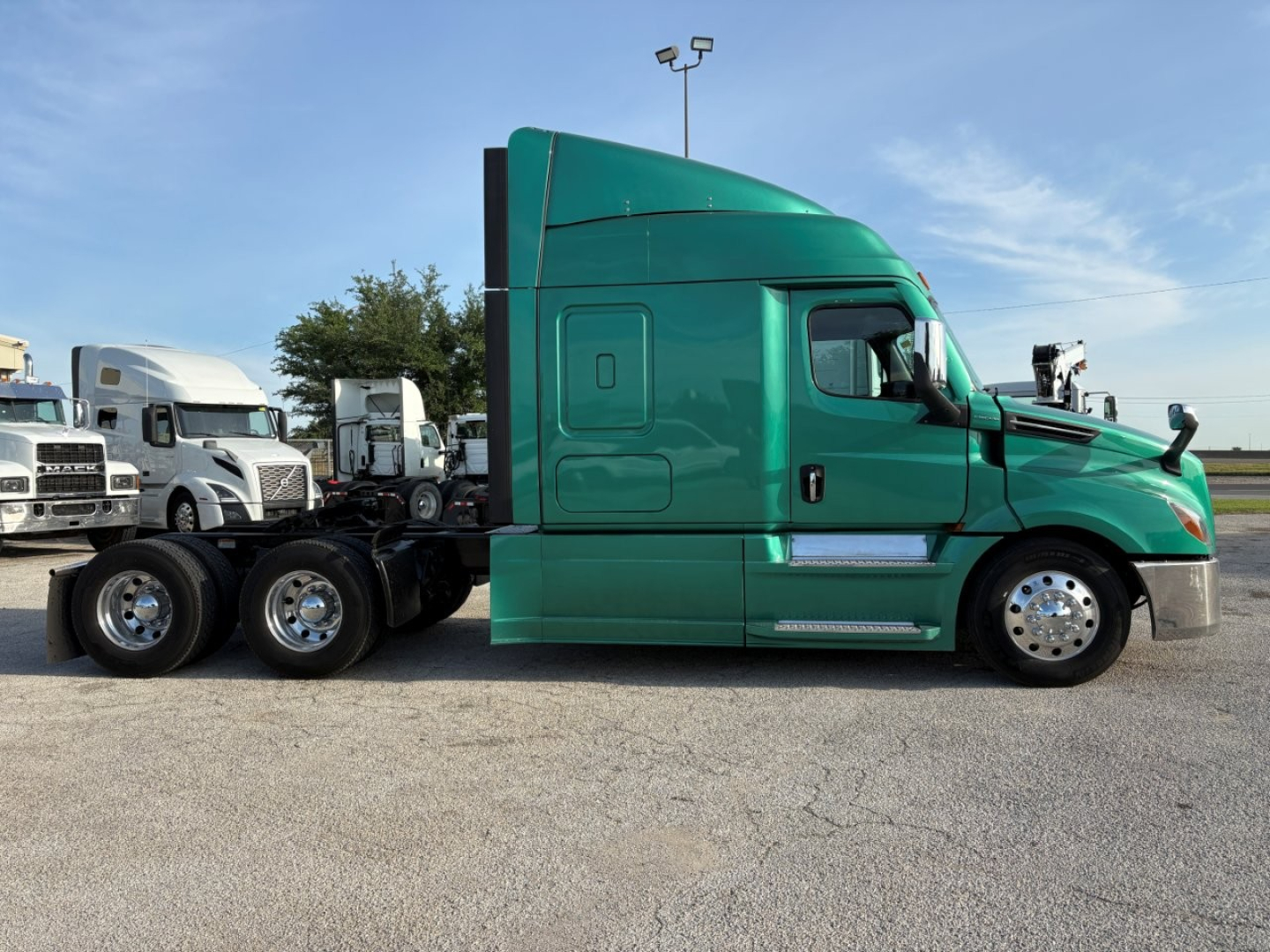 Truck side view showing a green Freightliner Cascadia 126 sleeper tractor without trailer.