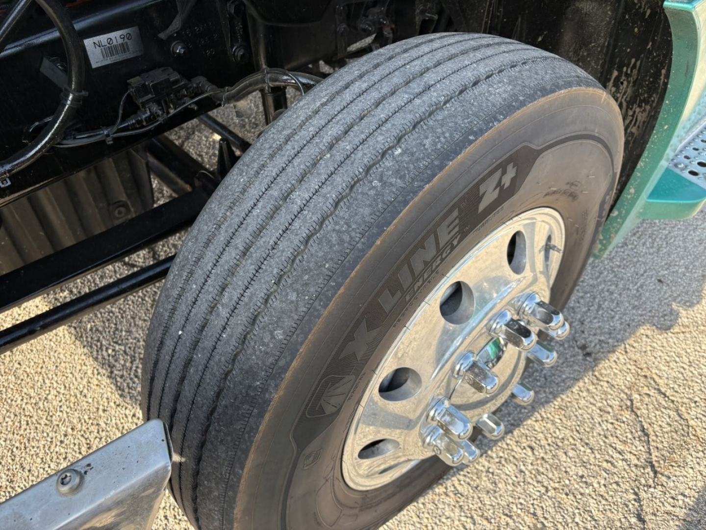 Tire and wheel of a Freightliner Cascadia 126 tractor showing front dual wheel with polished lug nuts and Goodyear tire tread.