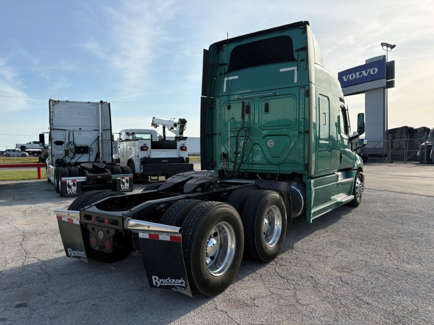 Freightliner Cascadia 126 tractor rear view showing tandem axles and green sleeper cab.