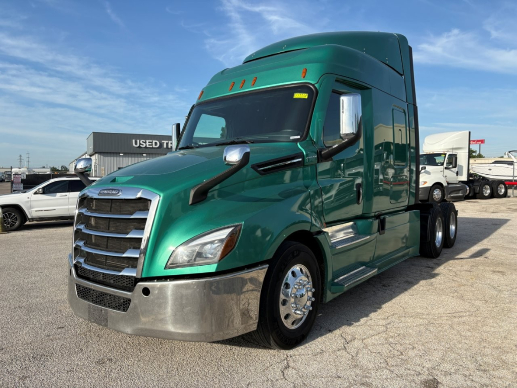 Freightliner Cascadia 126 tractor-trailer in green, front-left view showing chrome bumper, grille, and sleeper cab.