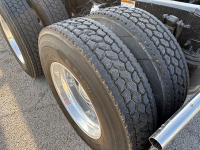 Freightliner Cascadia 126 truck axle and dual tires close-up showing tread pattern and wheel rims.