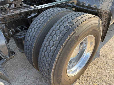 Truck axle and dual rear tires showing tread and chrome wheel on Freightliner Cascadia 126 chassis.
