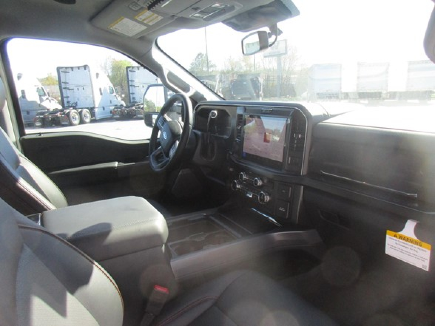 Ford F-350 interior cab with steering wheel, large touchscreen display, center console, and front seats. Dashboard shows infotainment system and controls.