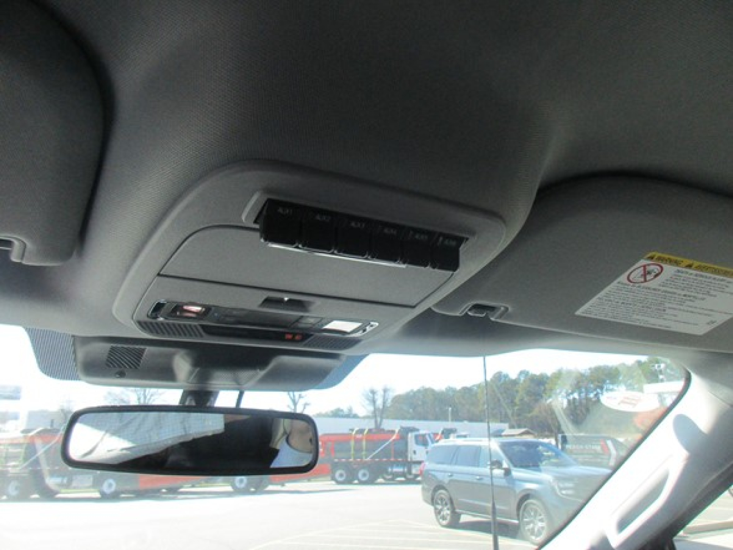 Interior overhead console with sunglasses holder and map lights showing rearview mirror and windshield view.