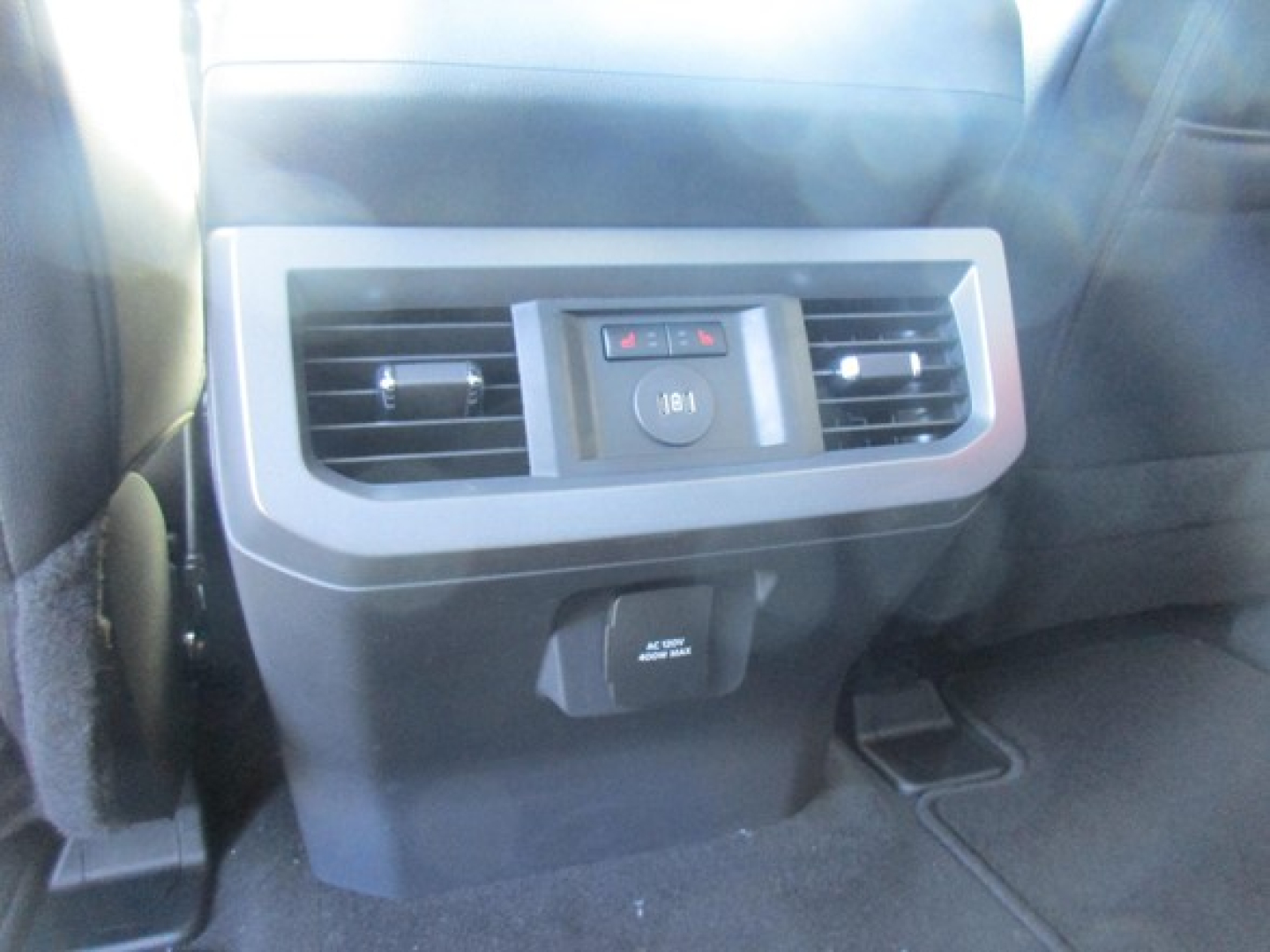 Ford F-350 interior rear seat area with rear climate vents and 12V/USB ports. Center console visible.